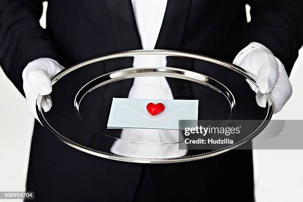 midsection of a man in a tuxedo holding a letter on a silver platter - formal letter stock pictures, royalty-free photos & images