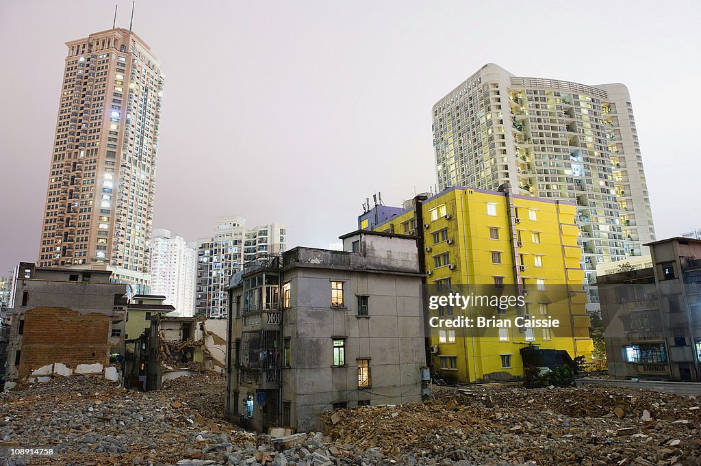 Old dilapidated buildings and rubble with modern buildings in background, Shenzhen, China
