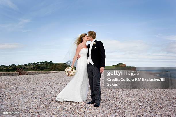 bride and groom on beach - couple sea uk stock pictures, royalty-free photos & images
