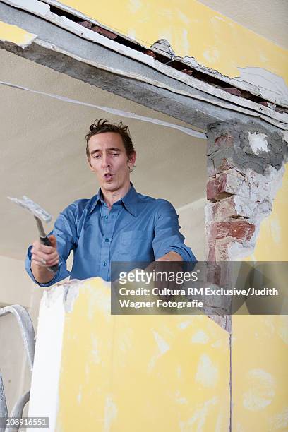 man knocking down wall - casser mur photos et images de collection