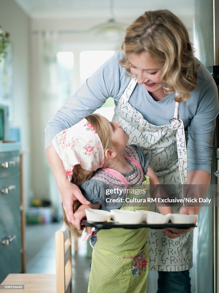 A mother helping her daughter to bake