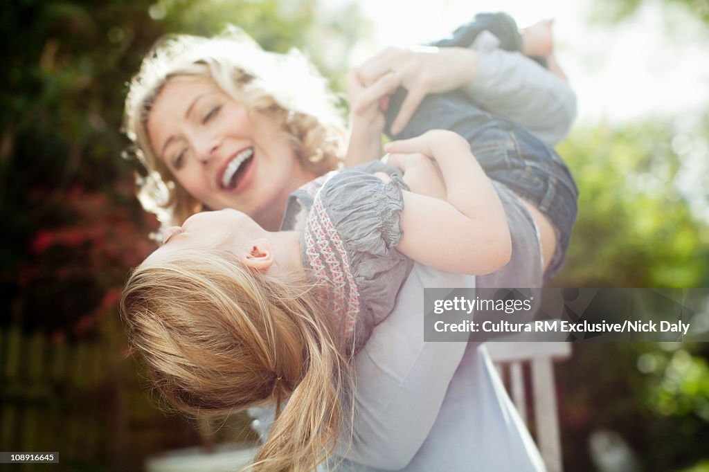 A mother holding her daughter in the air