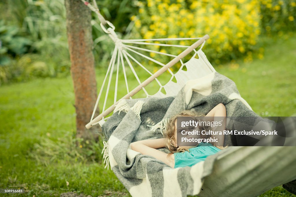 Girl resting in hammock in garden