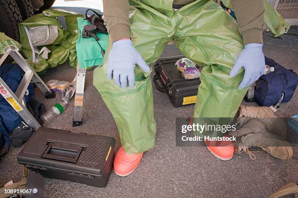 low section view of a hazmat firefighter sitting on a stool - hazmat suit stock pictures, royalty-free photos & images