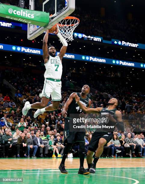 Jaylen Brown of the Boston Celtics dunks over Anthony Tolliver of the Minnesota Timberwolves and Josh Okogie during the fourth quarter at TD Garden...
