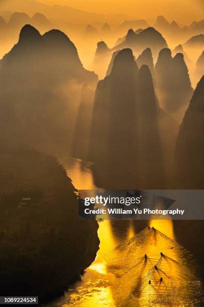 morning sunlight shining through hills over li river - formación karst fotografías e imágenes de stock