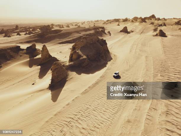 aerial view of white car on desert road - 4x4 desert stock-fotos und bilder
