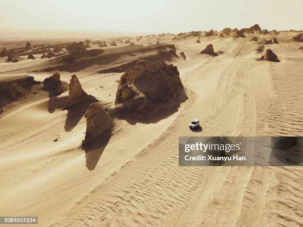 aerial view of white car on desert road - 4x4 desert stockfoto's en -beelden