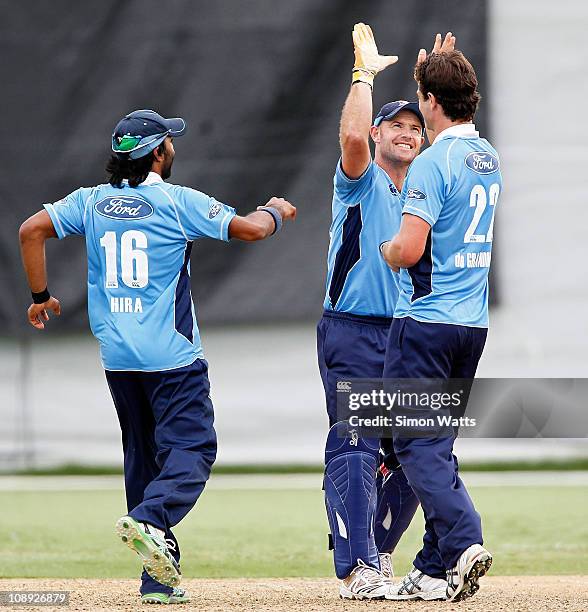 Gareth Hopkins of the Aces congratulates bowler Colin de Grandhomme for taking a wicket as teammate Ronald Hira runs in during the one day semi final...