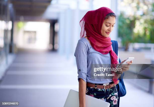 she can check her timetable on her device - hijab student stock pictures, royalty-free photos & images