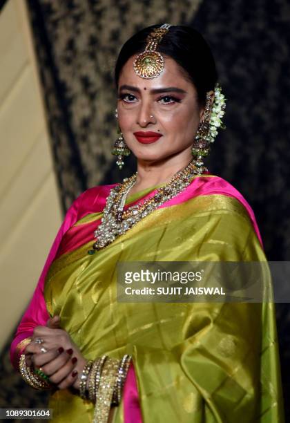 Indian Bollywood actress Rekha poses for a picture during the wedding reception of film producer Mukesh Bhatt's daughter Sakshi Bhatt, in Mumbai late...