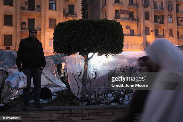 Anti-government protesters move about their makeshift encampment before sunrise in Tahrir Square on February 9, 2011 in Cairo, Egypt. While many...