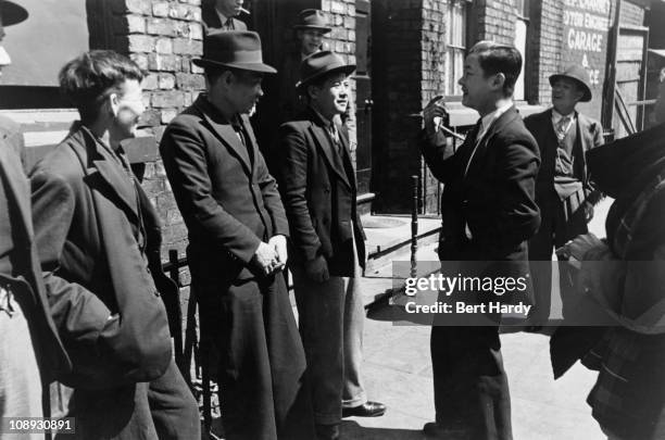 Group of Chinese seamen outside a Chinese hostel in Liverpool, May 1942. Original publication: Picture Post - 1136 - Chinese Hostel, Liverpool -...