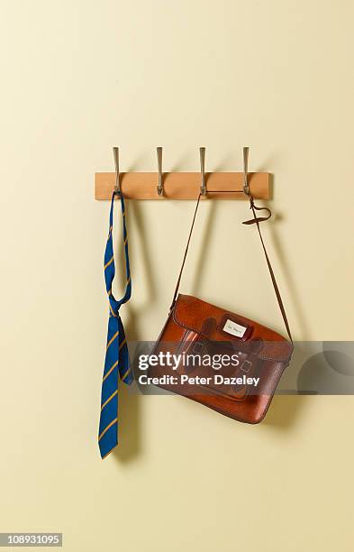 school tie and satchel on coat rack - school uniforms stock-fotos und bilder