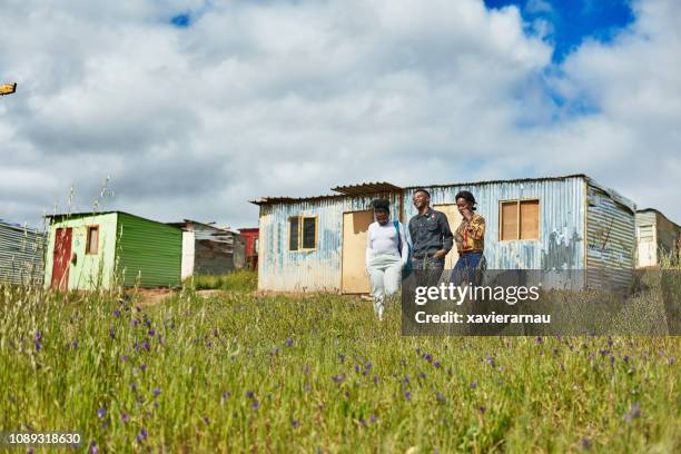 friends walking on field in townships of africa - south african culture stock pictures, royalty-free photos & images