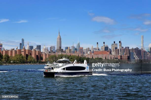 view from the east river of the waterfront of midtown manhattan on a clear sunny day. new york city, usa - nyc ferry stock pictures, royalty-free photos & images