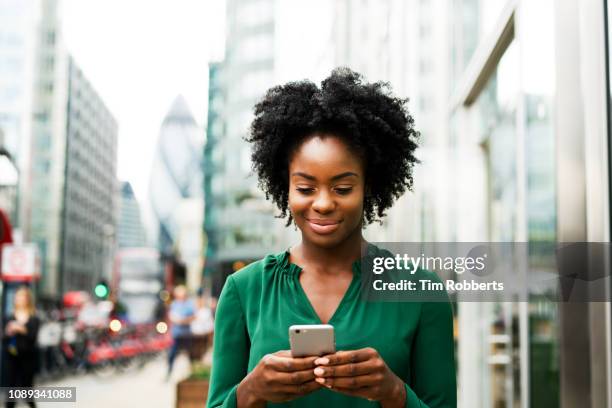 woman using smart phone in city - smartphone happy stock pictures, royalty-free photos & images