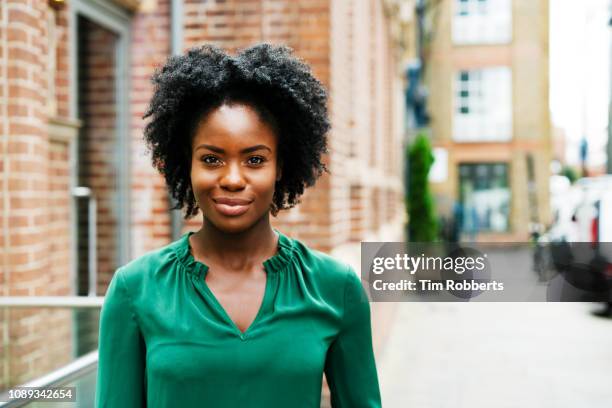 portrait of smiling woman on street - testimonial stockfoto's en -beelden