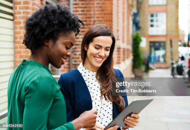two women discussing with tablet, smiling - london 2018 day 2 bildbanksfoton och bilder