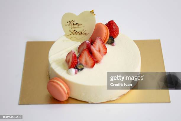 the rise of a strawberry birthday cake with pink macaron and chocolate written word, text  focus on the background - birthday cake ストックフォトと画像