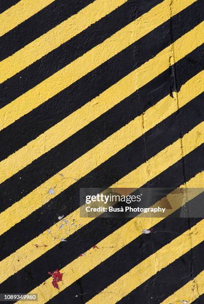 concrete wall painted with yellow and black stripes, usually used in construction sites with the meaning: do not enter the area / caution - animal markings foto e immagini stock