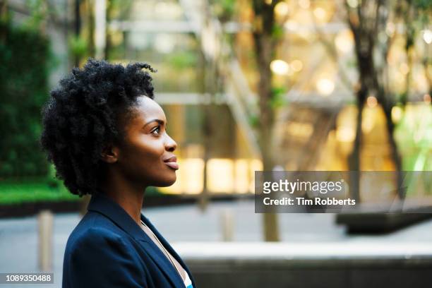 profile shot of woman looking ahead - afro hairstyle stock-fotos und bilder
