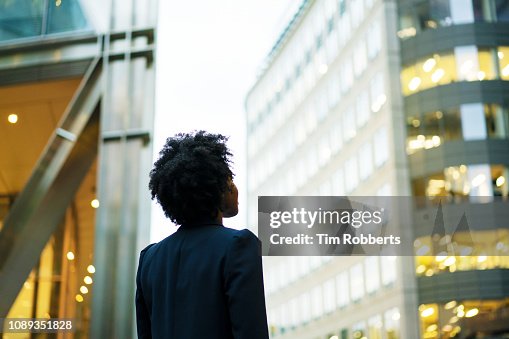 Woman looking up at office buildings Woman looking up at office buildings