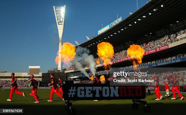 The Renegades run through flames onto the field during the Big Bash League match between the Melbourne Renegades and the Adelaide Strikers at GMHBA...