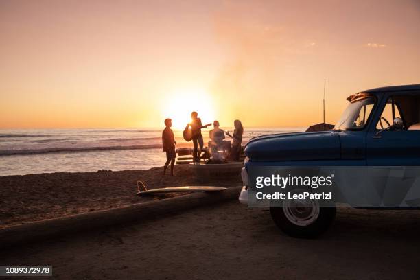 familienfest am strand in kalifornien bei sonnenuntergang - kalifornien stock-fotos und bilder