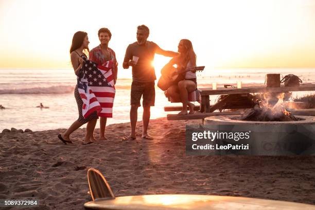 familienfest am strand in kalifornien bei sonnenuntergang - american flag beach stock-fotos und bilder