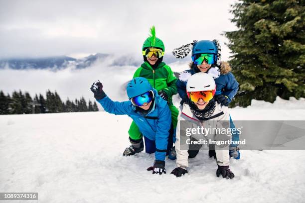 skiing family posing to a funny picture. - funny snow skiing stock pictures, royalty-free photos & images