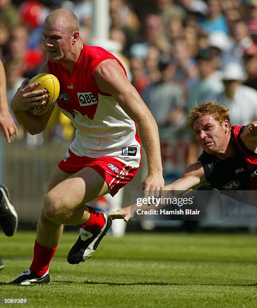 Barry Hall for Sydney is pursued by Gary Moorcroft for Essendon, during the AFL practice match between the Sydney Swans and the Essendon Bombers,...