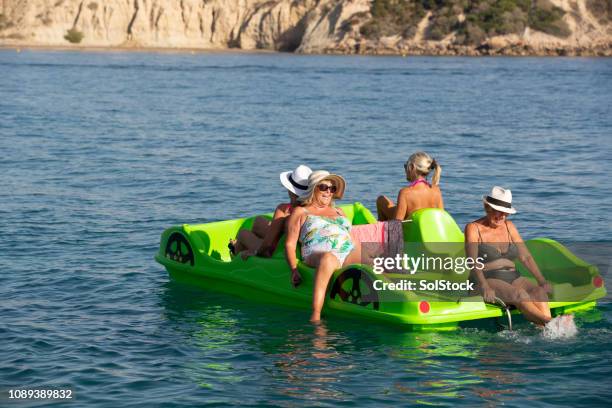 senior women relaxing on the summer sea - pedal boat stock pictures, royalty-free photos & images