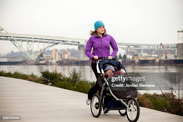 mother exercising with her young child. - three wheeled pushchair stock pictures, royalty-free photos & images