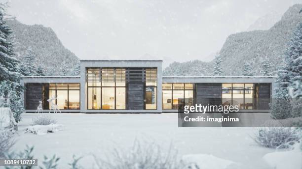 moderne berghaus in schneereichen wetter - modern house dusk stock-fotos und bilder