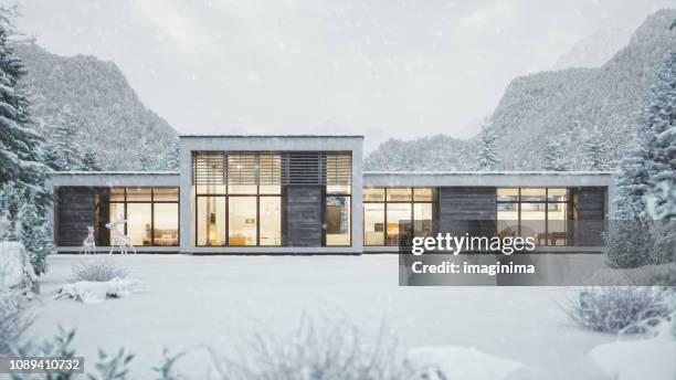 modern mountain house in snowy weather - mountains dusk stock pictures, royalty-free photos & images