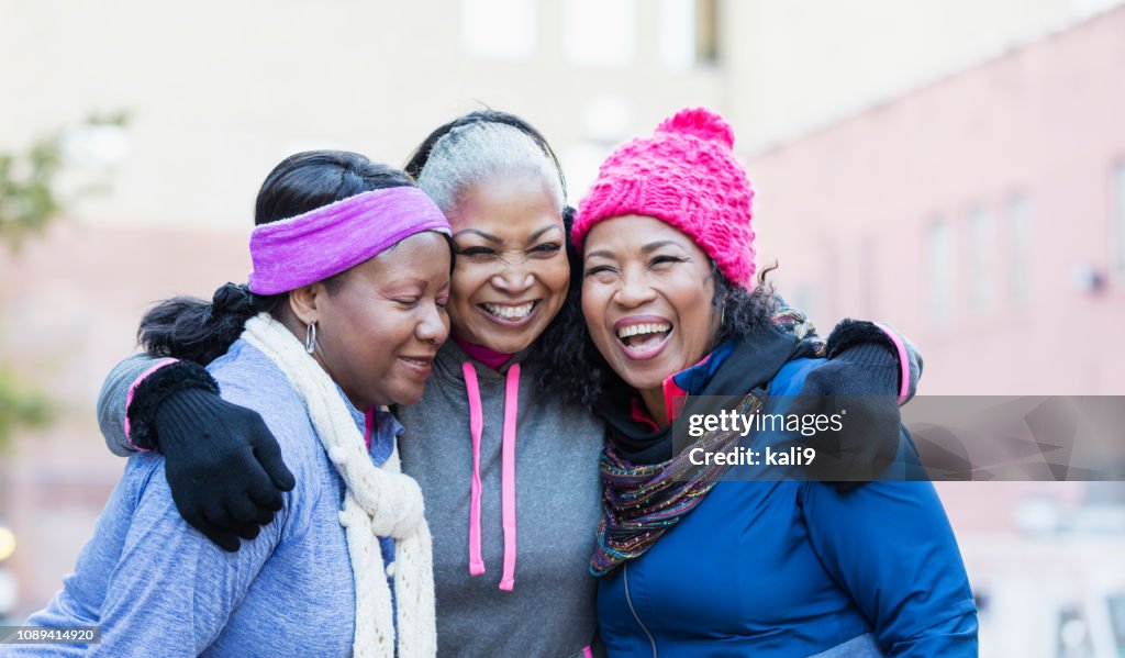 African-American women in city, laughing, hugging