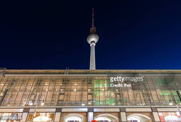 berlin railway station alexanderplatz and television tower at blue hour (berlin, germany) - alexanderplatz stock-fotos und bilder