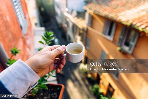 drinking espresso on the balcony in rome, personal perspective view - espresso trinken stock-fotos und bilder