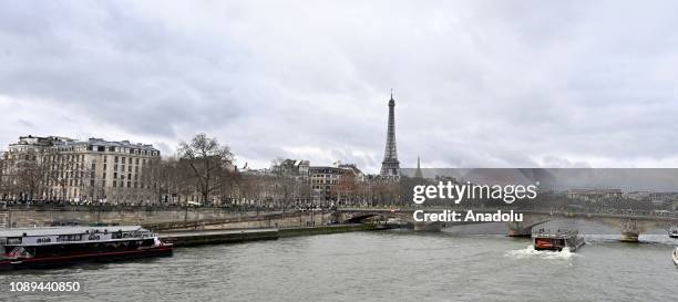 French yellow vests protesters walk near the Eiffel Tower during a demonstration against deteriorating economic conditions in Paris, France on...