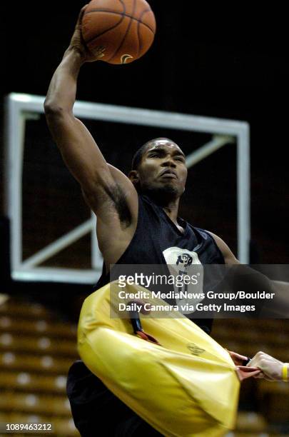 University of Colorado freshman forward Jeremy Williams goes up for a shot through a blocking pad being swung at him by a coach during the men's...