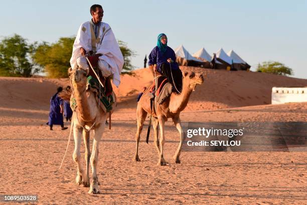 Picture taken on January 24 shows a camel guide riding a dromedary during the 10th edition of the "Nomad Festival" in Ivijaren, some 118 km east of...