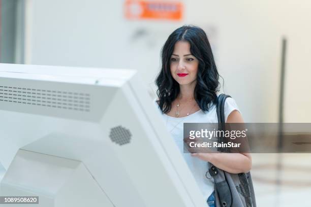 women using touch screen kiosk in shopping mall - shopping centre screen stock pictures, royalty-free photos & images