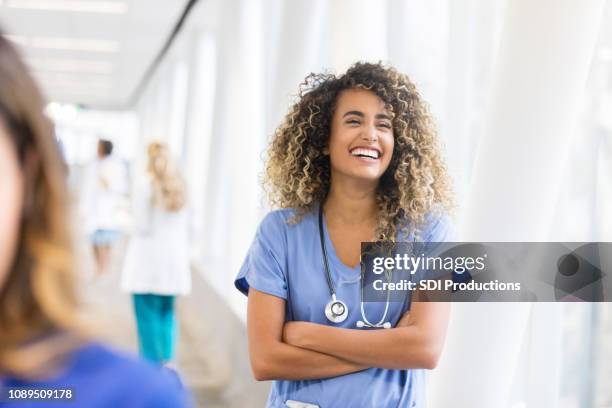 fröhliche krankenschwester im krankenhaus skybridge - krankenhaus personal stock-fotos und bilder