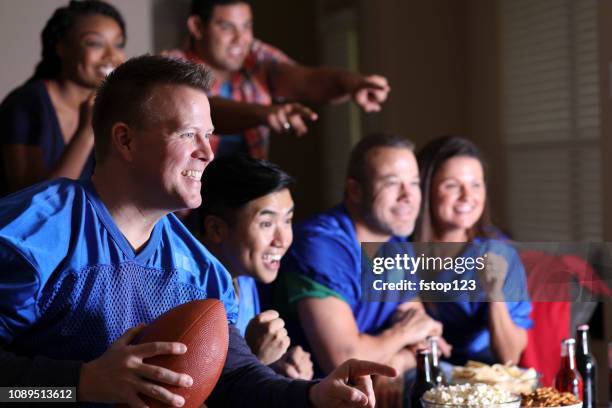 football fans watching the game at home on television. - sports jersey home stock pictures, royalty-free photos & images