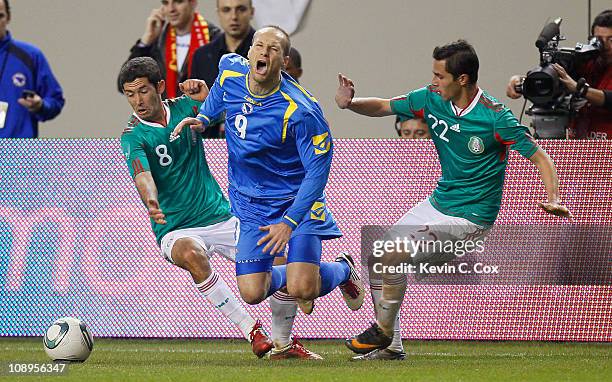 Zlatan Muslimovic of Bosnia-Herzegovina is tripped up by Israel Castro and Paul Aguilar of Mexico during an international friendly match at Georgia...