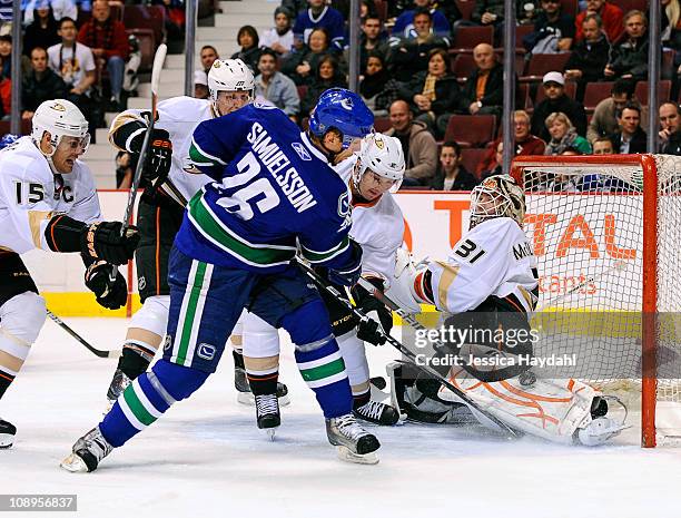 Curtis McElhinney of the Anaheim Ducks makes a save on Jannik Hansen of the Vancouver Canucks, while Ryan Getzlaf, Lubomir Visnovsky and Toni Lydman...