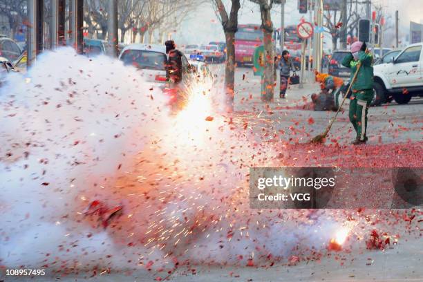 Fireworks explode outside a shopfront on February 9, 2011 in Dalian, Liaoning Province of China. Local businesses in China rushed to set off...