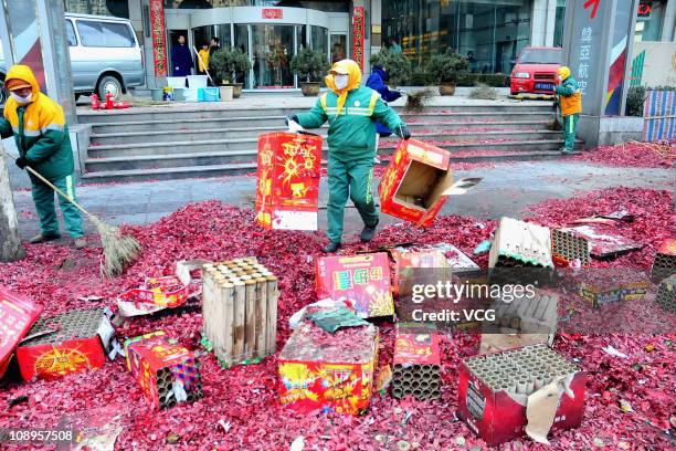 Cleaners remove used fireworks on February 9, 2011 in Dalian, Liaoning Province of China. Local businesses in China rushed to set off fireworks ahead...