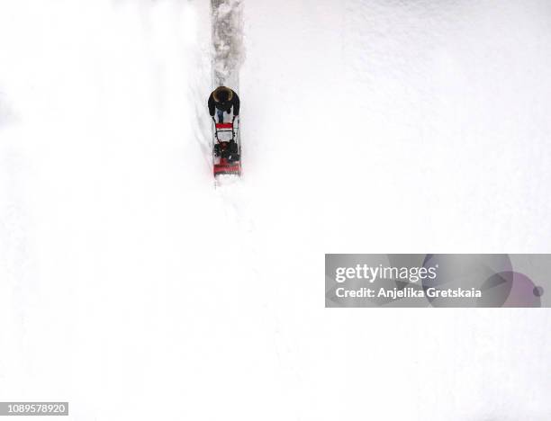 man using a snow blowing machine, canada, aerial view - removedor de neve ferramenta de trabalho - fotografias e filmes do acervo